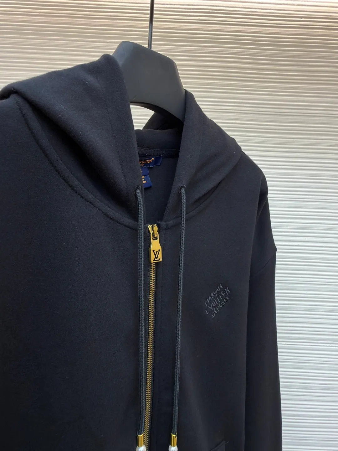 LOUIS VUITTON Pearl Pendant Zipper Jacket ●Original version: Purchased and developed for 10999 ●Item number: 1682253-B60 ●Fabric: wool blended fabric ●Technology: knitted embroidery production ●Color: black ●Version: fitted version ●Weight: about 715 grams ●Size: S-M-L-XL ●Description: This Louis Vuitton black hooded zipper sweatshirt is made of high-weight pure cotton waffle fabric. The fabric has been combed and singed, with a uniform and fine surface texture. It is also treated with anti-pilling and pre-shrunk, making it soft to the touch and not easily deformed after long-term wear. The brand logo on the left side of the body adopts the same color dark pattern embossing process and is hot-pressed through a temperature-controlled mold. The pattern is low-key and has a strong three-dimensional effect. The drawstring is embellished with custom-made pearl decorations, which are fixed by hand-beading. The surface of the pearls is polished to have a good luster and will not fall off easily. The metal zipper is made of gold-plated brass and has been treated with antioxidant treatment. The chain head is engraved with the brand's classic logo, making it smooth and wear-resistant. The ribs on the cuffs and hem are made of spandex blended material, which has excellent resilience and is not easy to loosen. The overall design is cut with loose shoulders, combined with double-needle hemming and seamless splicing technology. The stitching is fine and flat, which not only ensures comfort, but also shows the exquisite craftsmanship and brand texture of high-end garments. The overall wiring is straight and delicate, the fabric is comfortable and soft, and the color is consistent without color difference. It can be matched with the same style to create a fashionable look and control various occasions. Customized accessories, complete with three standards, same style for men and women!